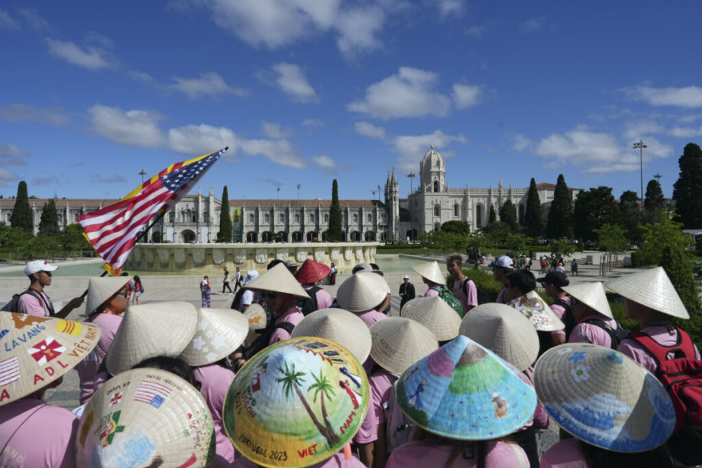 A group of Vietnamese from the United States travelling to attend International World Youth Day stand in front of the 16th century Jeronimos monastery in Lisbon, Tuesday, on 1st August 2023.
