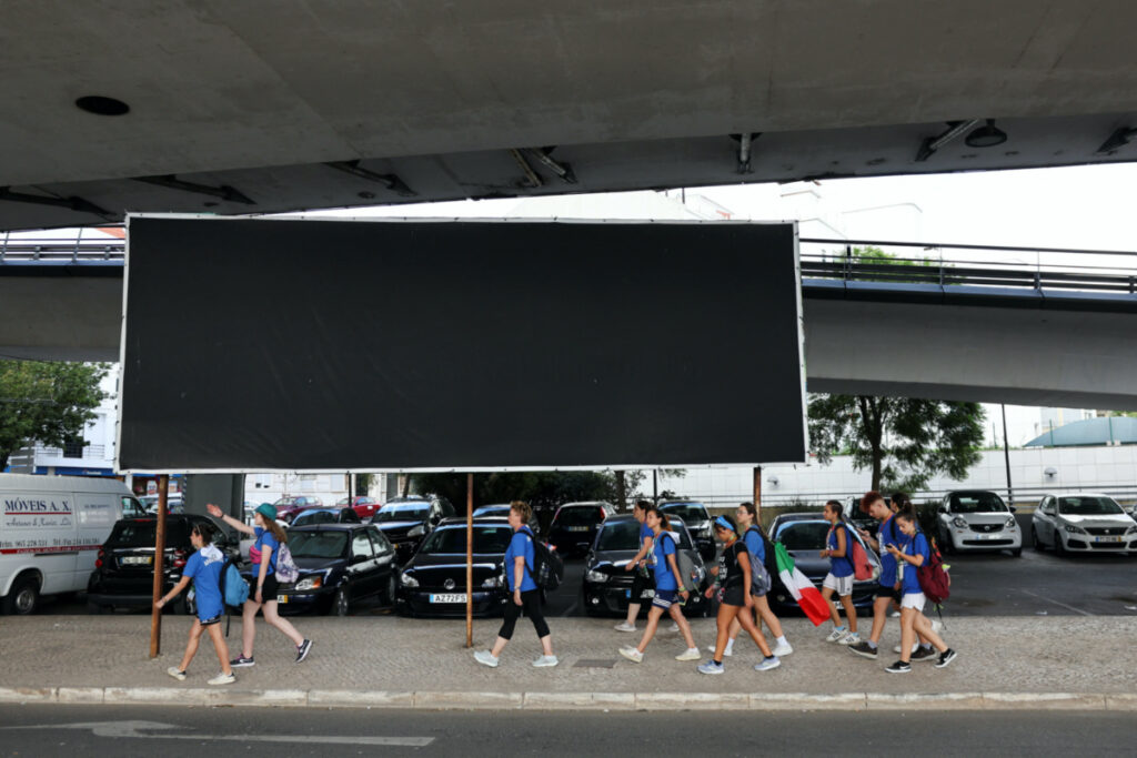 Pilgrims walk past a blackened out billboard, in the Portuguese municipality of Oeiras, after the town hall ordered the removal of a sign denouncing clergy sex abuse, during the XXXVII World Youth Day in Lisbon, Portugal, on 2nd August, 2023.