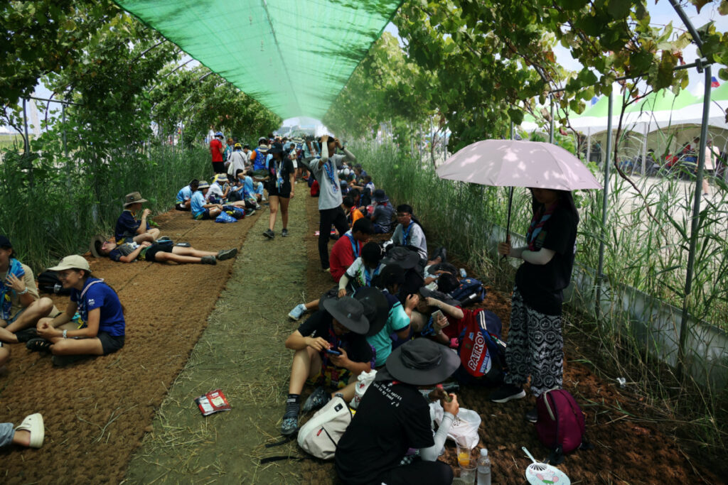Participants take shelter from the strong sunlight at the camping site for the 25th World Scout Jamboree in Buan, South Korea, on 4th August, 2023.