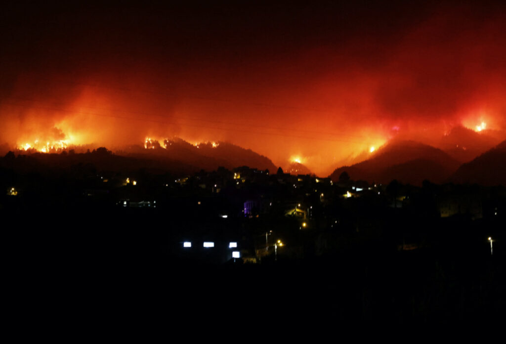 A view shows fire over the mountains in the village of La Victoria, as wildfires rage out of control on the island of Tenerife, Canary Islands, Spain, on 19th August, 2023.