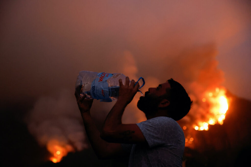 Resident of the town of Aguamansa drinks water, as wildfires rage out of control on the island of Tenerife, Canary Islands, Spain, on 17th August, 2023.