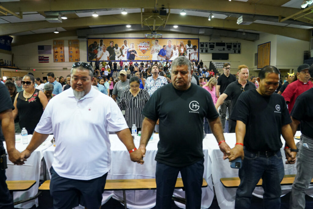 Residents clasp hands in prayer during a community event at the Lahaina Civic Center, in the fire-ravaged town of Lahaina on the island of Maui in Hawaii, US, on 21st August, 2023