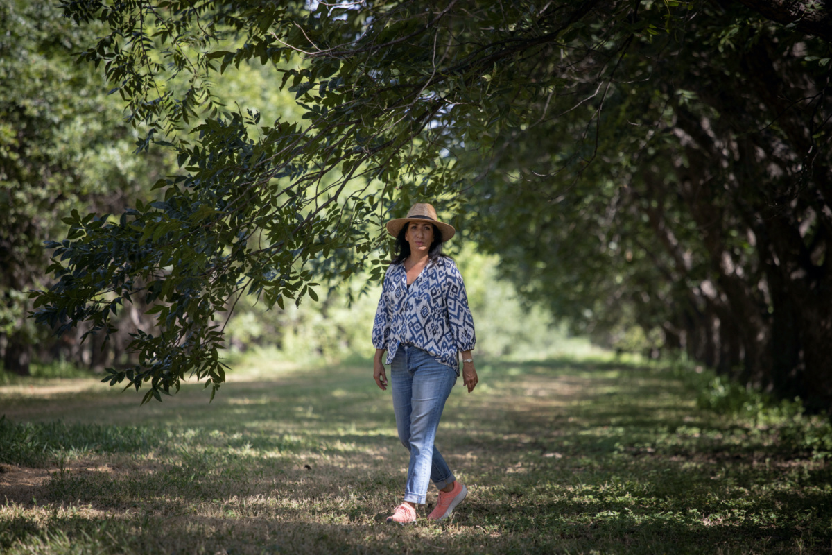 Magali Urbina, co-owner of Heavenly Farms, walks through her pecan orchard along the Rio Grande river in Eagle Pass, Texas, US, on 27th July, 2023.