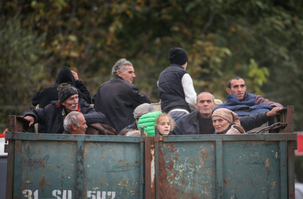 Refugees from Nagorno-Karabakh region ride in the back of a truck as they arrive in the border village of Kornidzor, Armenia, on 26th September, 2023.