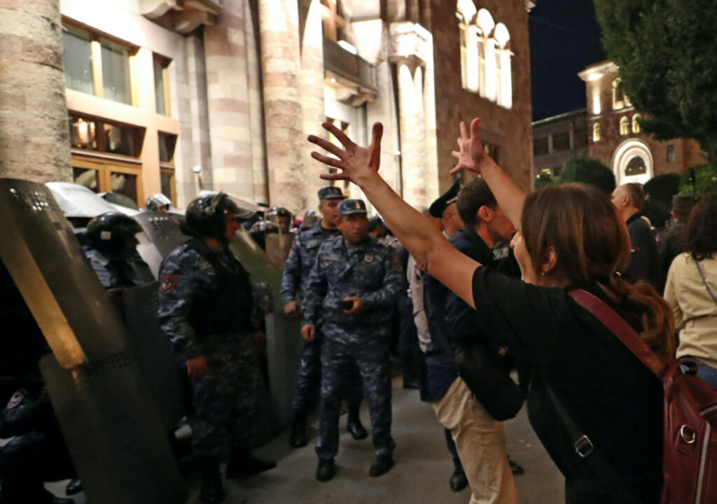 A protester reacts next to law enforcement officers who stand guard outside the government building during a rally to demand the resignation of Armenian Prime Minister Nikol Pashinyan following Nagorno-Karabakh surrender, in Yerevan, Armenia, on 21st September, 2023