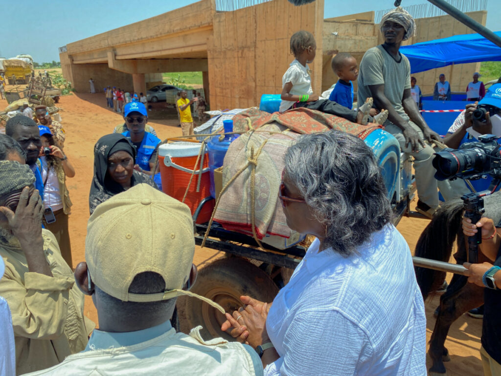 US Ambassador to the United Nations, Linda Thomas-Greenfield, speaks with Sudanese refugees as they cross the border - marked by the unfinished bridge structure in the background - into Chad to flee the country's conflict, in Adre, Chad, on 6th September, 2023