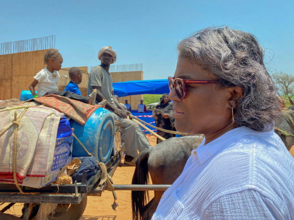 US Ambassador to the United Nations, Linda Thomas-Greenfield, speaks with Sudanese refugees as they cross the border - marked by the unfinished bridge structure in the background - into Chad to flee the country's conflict, in Adre, Chad, on 6th September, 2023