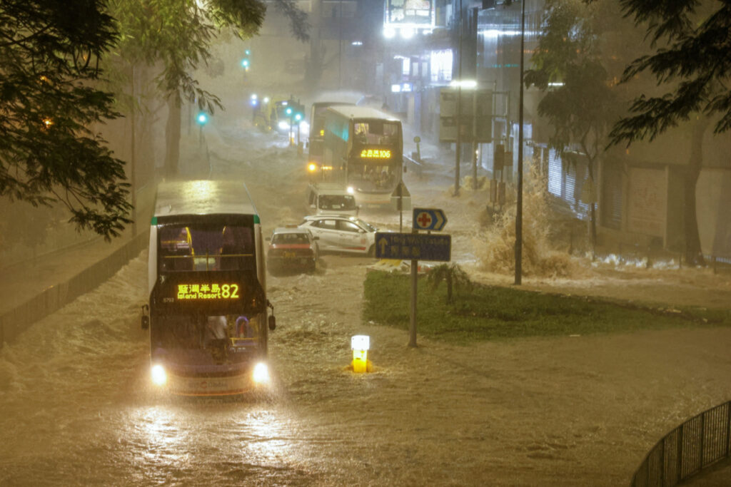 A bus drives past a flooded area during heavy rain, in Hong Kong, China, on 8th September, 2023