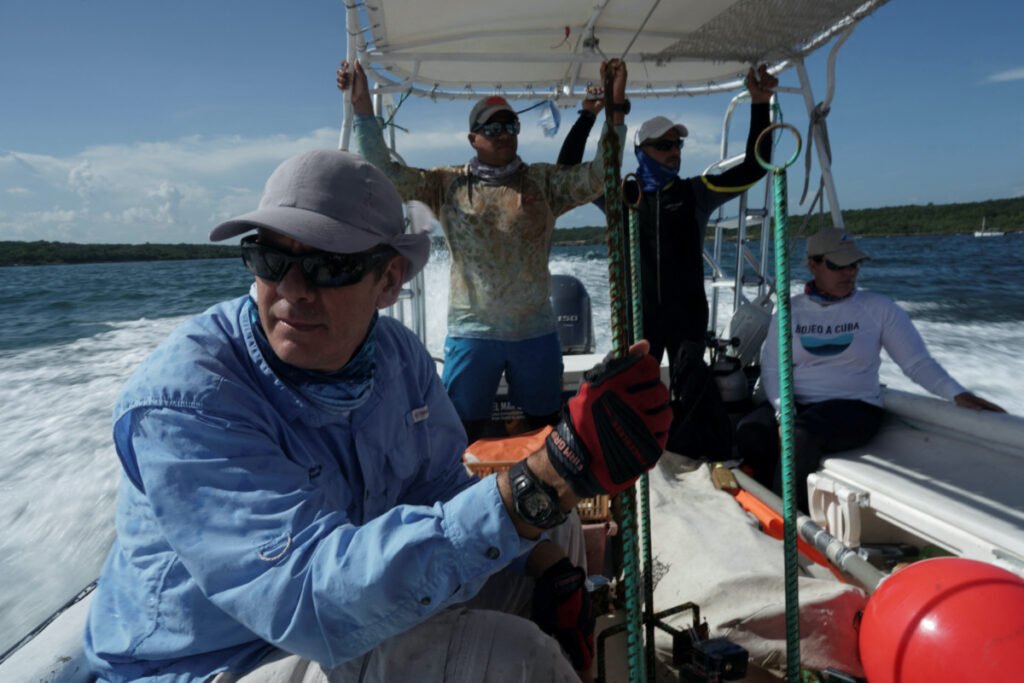 Fabian Pina, Cuban marine biologist and expedition co-leader, together with other scientists and crew members of the "Bojeo a Cuba" study prepare to release camera traps to photograph sharks near the coast of Cienfuegos, Cuba, on 31st August, 2023