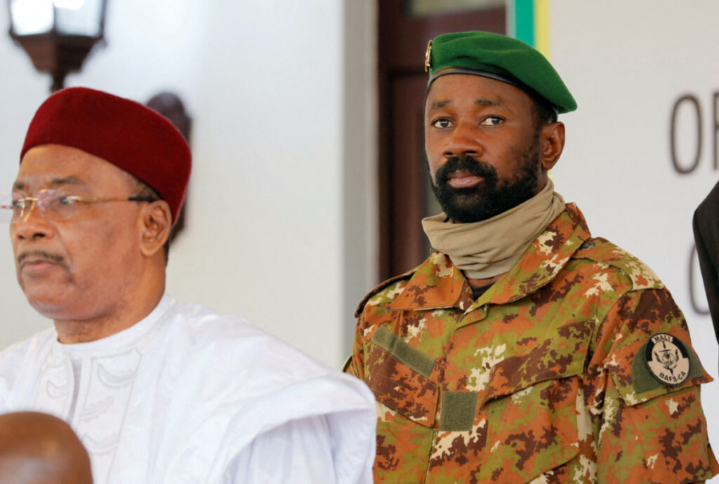Colonel Assimi Goita, leader of Malian military junta, looks on while he stands behind Niger's President Mahamadou Issoufou during a photo opportunity after the Economic Community of West African States consultative meeting in Accra, Ghana, on 15th September, 2020