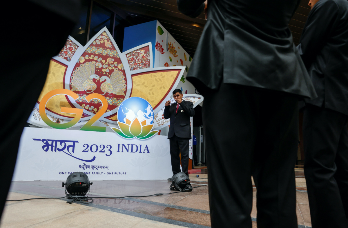 Indian security pose for selfies in front of a G20 sign outside the International Media Center during the G20 Summit in New Delhi, India, on 9th September, 2023.