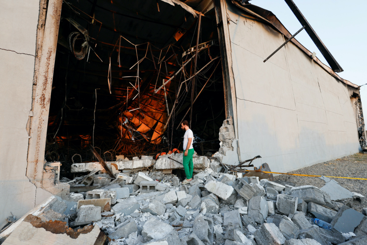 A person stands on rubble at the site following a fatal fire at a wedding celebration, in the district of Hamdaniya in Iraq's Nineveh province, Iraq, on 27th September, 2023. 