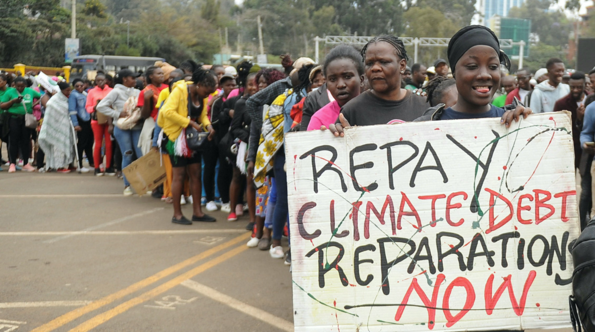 A member of the civil society holds a placard as others queue during a peaceful protest against the continent's inaugural climate summit, marching against the use of fossil fuels in the region while demanding that governments and industries transition to renewable energy in Nairobi, Kenya, on 4th September, 2023