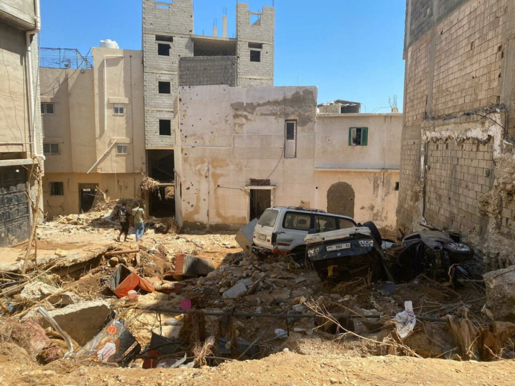 People walk amidst the wreckage, in the aftermath of the floods in Derna, Libya, on 15th September, 2023