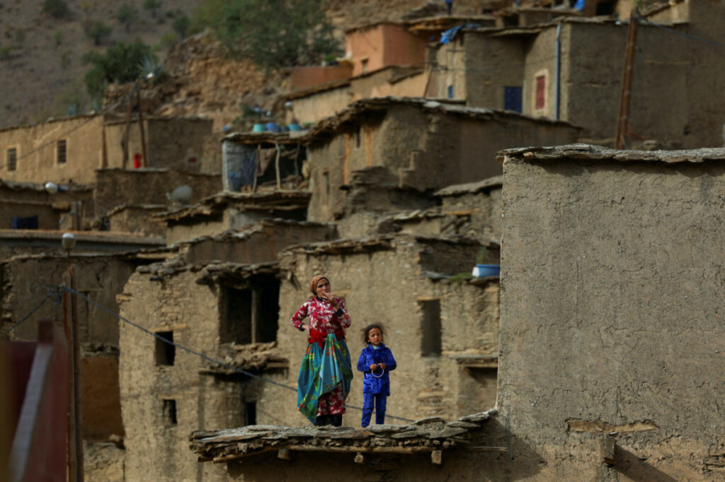 People affected by a deadly earthquake stand on a house, in the rural village of Azermoun, Morocco, on 14th September, 2023