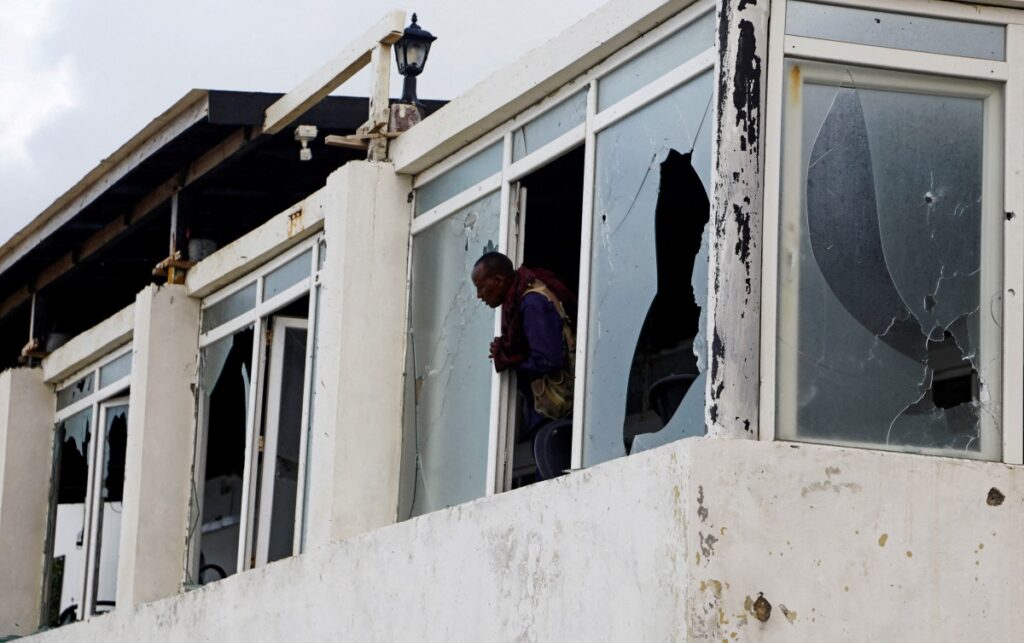 A Somali police officer looks from the broken windows of the Pearl Beach Restaurant following an attack by al-Shabaab militants at the Liido beach in Mogadishu, Somalia on 10th June, 2023