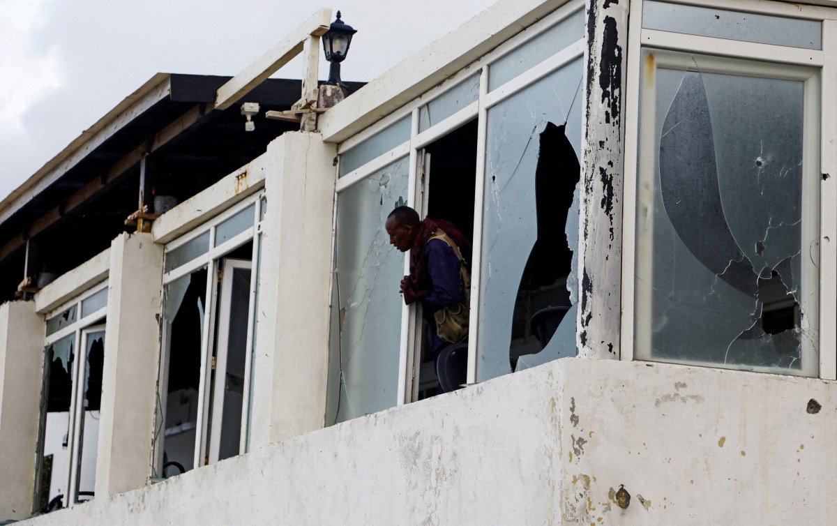 A Somali police officer looks from the broken windows of the Pearl Beach Restaurant following an attack by al-Shabaab militants at the Liido beach in Mogadishu, Somalia on 10th June, 2023