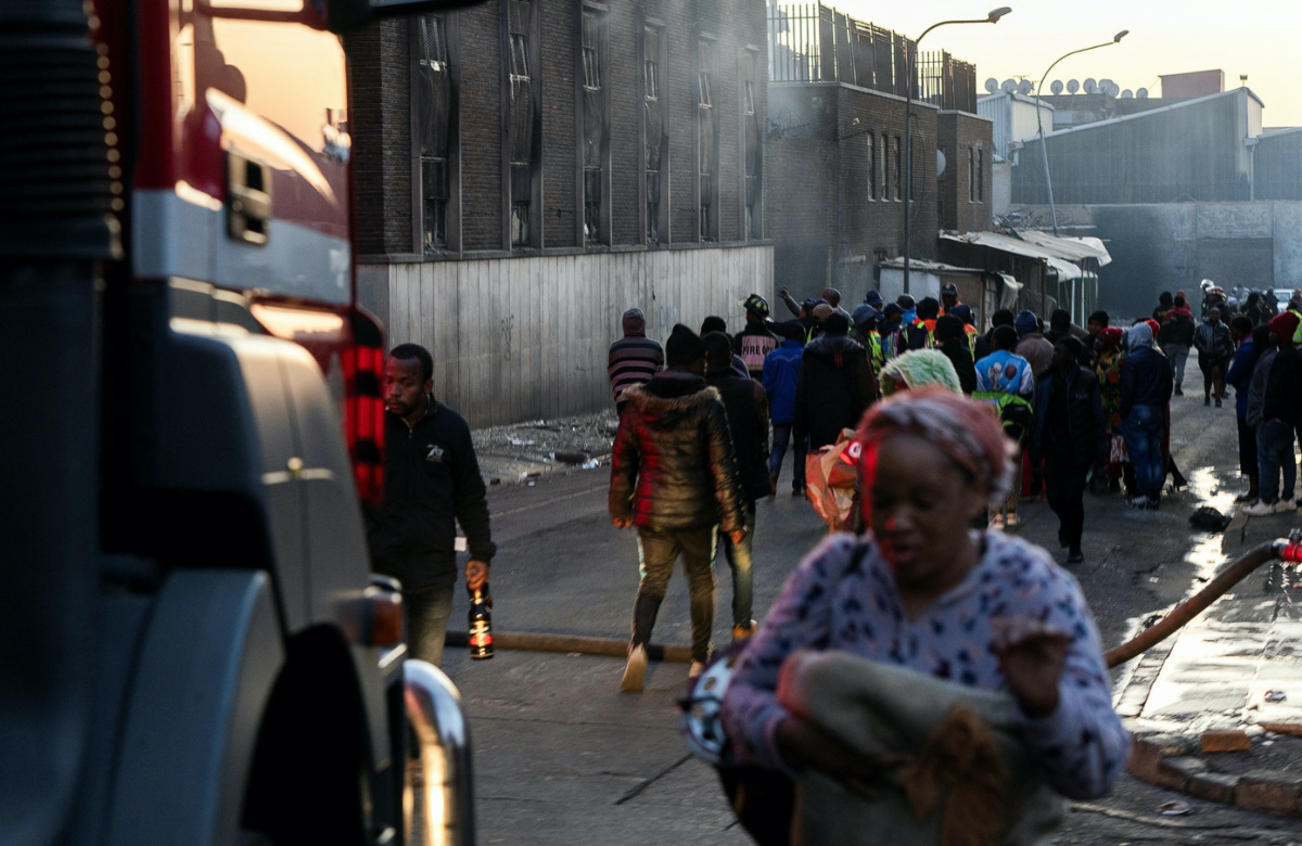 People walk past a building after a deadly blaze in the early hours of the morning, in Johannesburg, South Africa, on 31st August, 2023