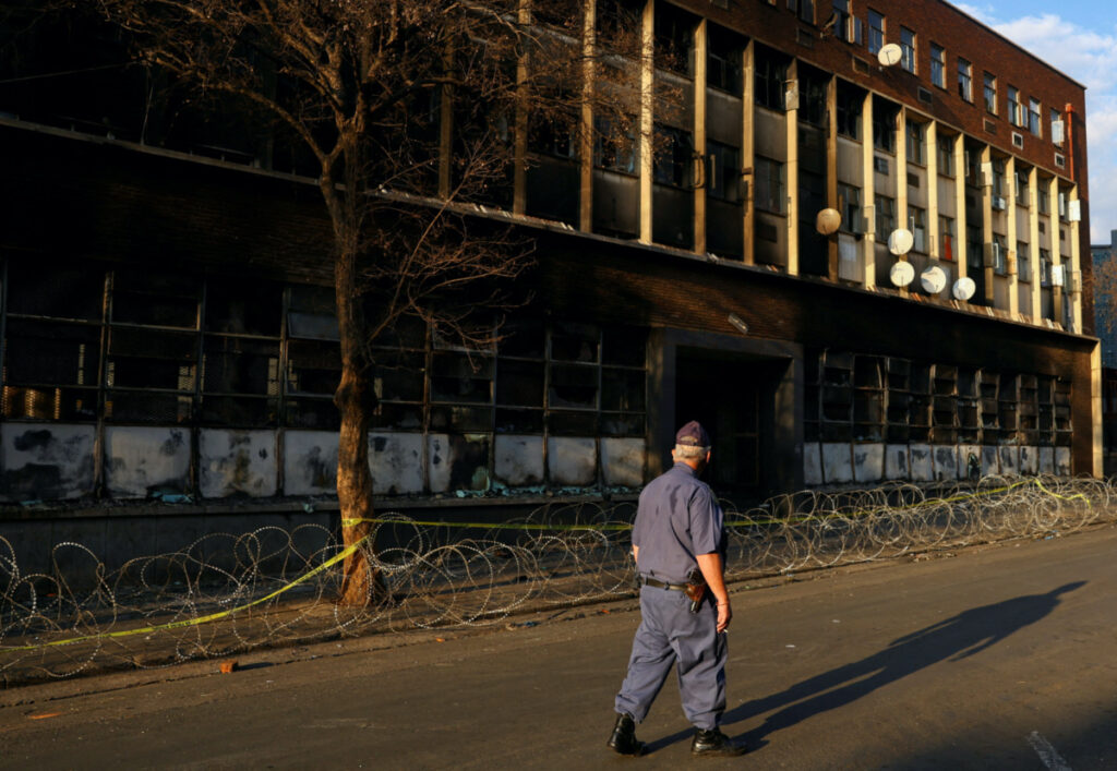 A police officer walks past the apartment block where a deadly fire broke out, in Johannesburg, South Africa, on 1st September 2023