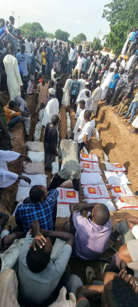 People place bodies into a mass grave in the aftermath of a strike near a bridge that killed dozens of people, in Nyala, Sudan, on 23rd August, 2023