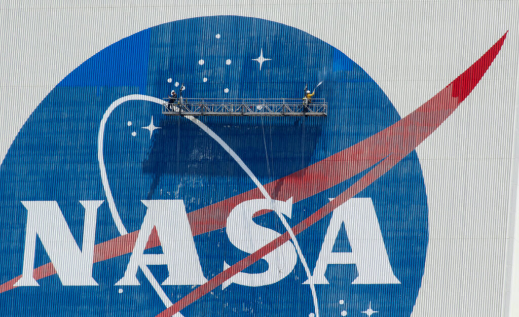 Workers pressure wash the logo of NASA on the Vehicle Assembly Building before SpaceX will send two NASA astronauts to the International Space Station aboard its Falcon 9 rocket, at the Kennedy Space Center in Cape Canaveral, Florida, US, on 19th May, 2020