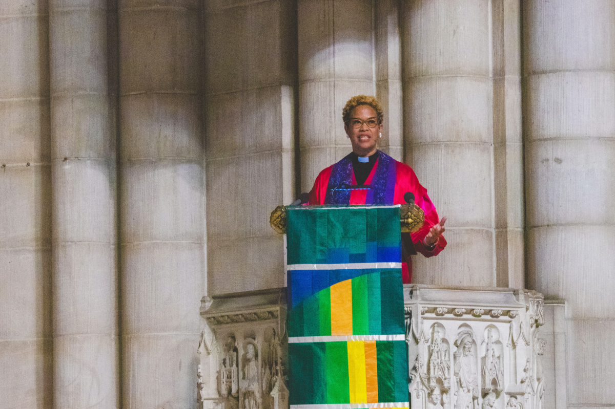Rev Adriene Thorne holds a banner during up to be hung in the church after being installed minister at Riverside Church in New York