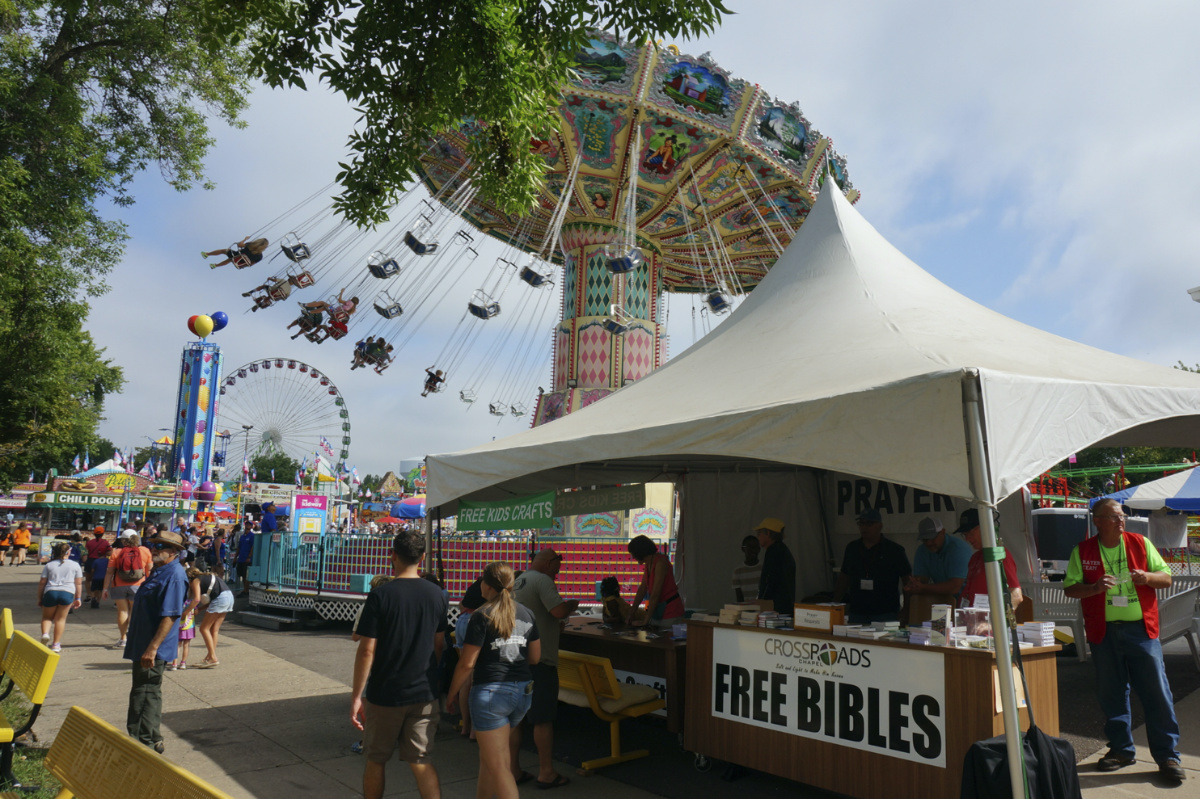 Dean Wiberg, right, volunteers at the evangelical Crossroads Chapel tent, which distributes thousands of free Bibles during the Minnesota State Fair in Falcon Heights, Minnesota, on Thursday, 24th August, 2023