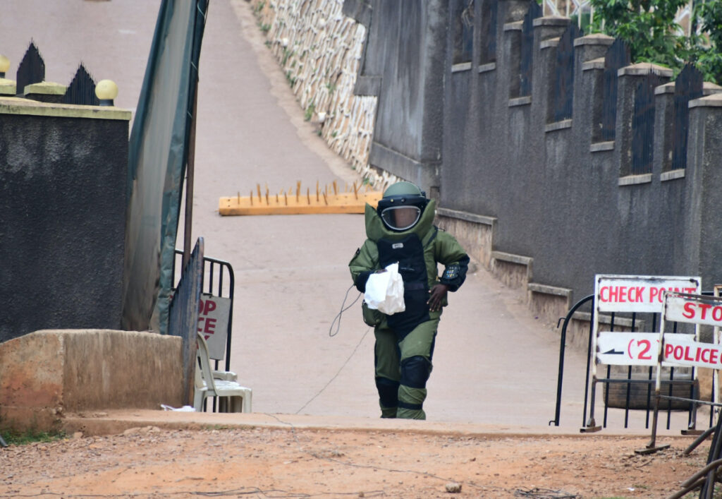 A bomb disposal expert dressed in his protective suit carries samples after a controlled detonation of an explosive device outside a Pentecostal church, Lubaga Miracle Centre, in the Lubaga suburb of south Kampala, Uganda, on 3rd September, 2023
