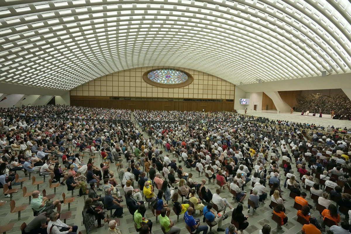 People listen to Pope Francis, white figure on stage, during his weekly general audience in Paul VI Hall, at the Vatican, Wednesday, 8th September, 2021