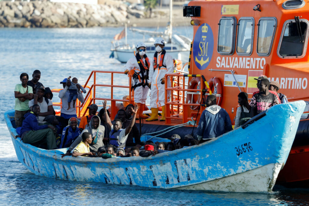 A group of migrants in a wooden boat are towed by a Spanish coast guard vessel to the port of Arguineguin, in the island of Gran Canaria, Spain, on 12th October, 2023.