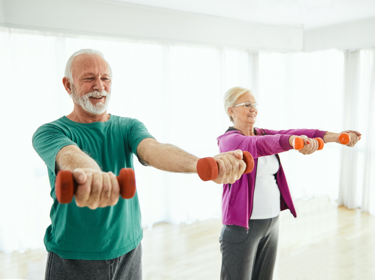 Senior couple exercise stretching and exercising with dumbbell lifting weigth at home health care 