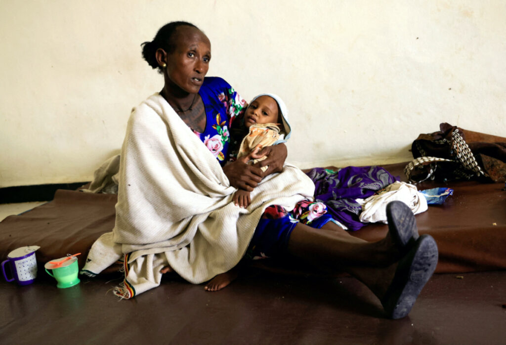 Maeru Adugna, 45 carries her son, Kibrom Woldesillasie, two, severely malnourished due to the food aid suspension from the United Nations World Food Program and the US Agency for International Development at the Samre Hospital in Samre, Tigray Region, Ethiopia, on 23rd June, 2023