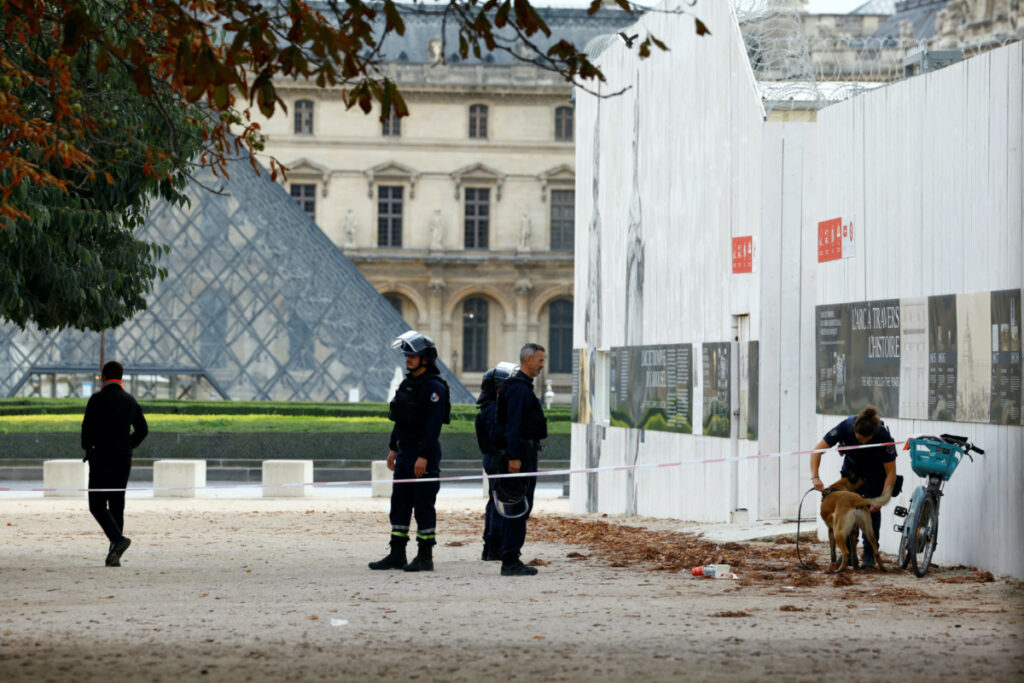 French police officers keep watch in front of the Louvre museum, closed for security reasons, in Paris, as French government puts the nation on its highest state of alert after a deadly knife attack in northern France, on 14th October, 2023