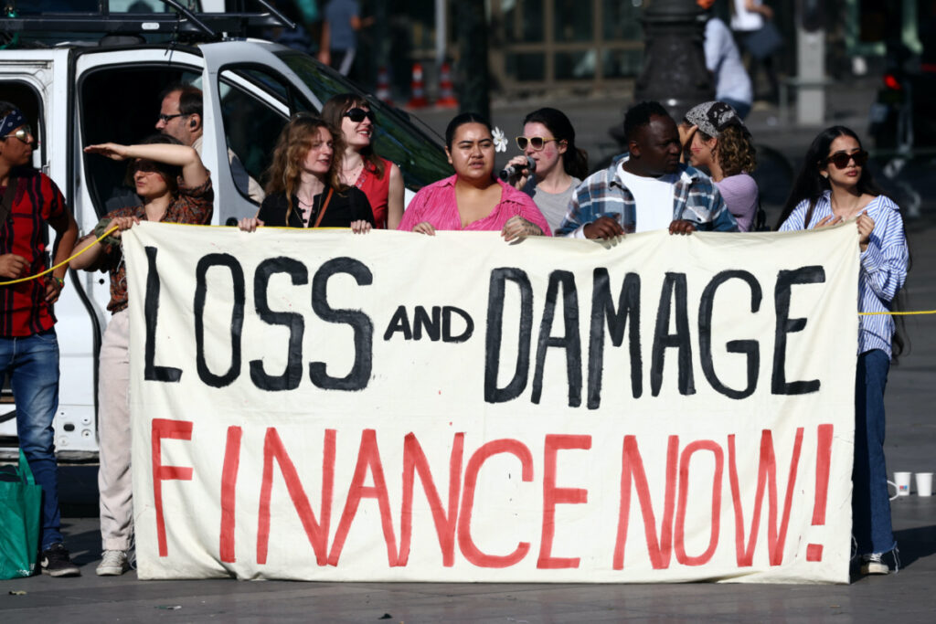 Environmental activists hold a banner with the slogan "Loss and damage, finance now" during a climate strike action at the Place de la Republique, on the sidelines of the New Global Financial Pact Summit, in Paris, France, on 23rd June, 2023