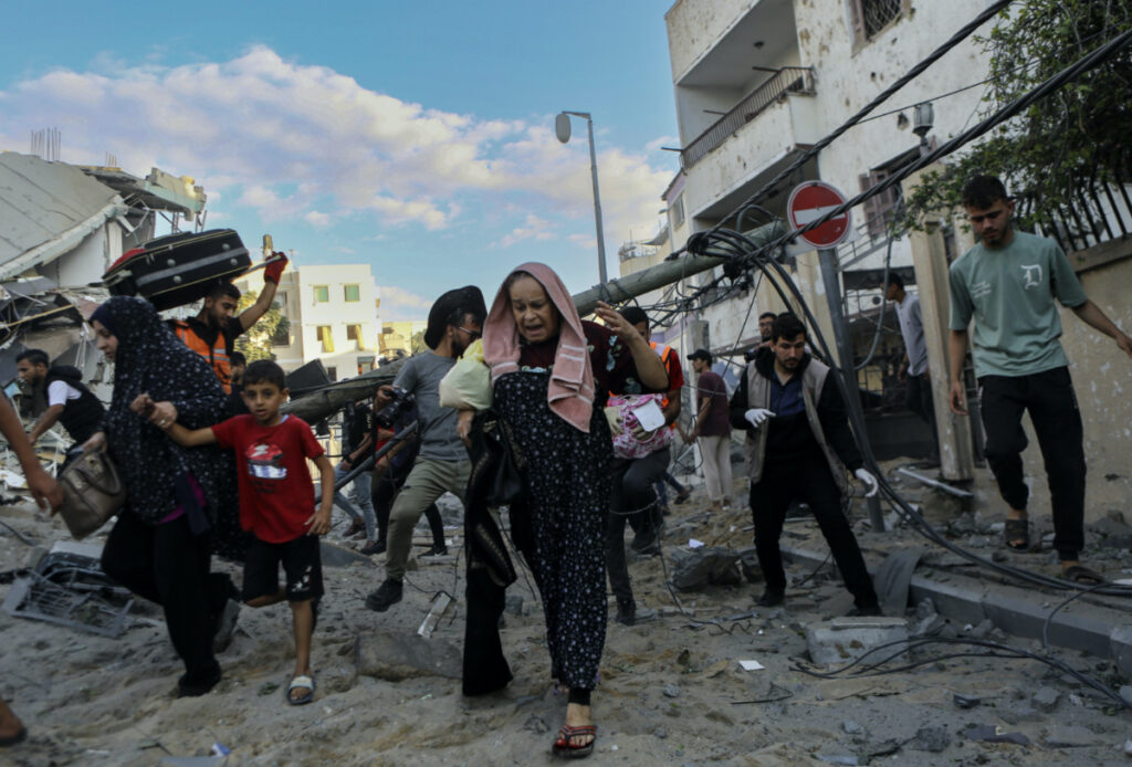 Palestinian families rush out of their homes after Israeli airstrikes targeting their neighbourhood in Gaza City, central Gaza Strip, on Tuesday, 17th October 2023