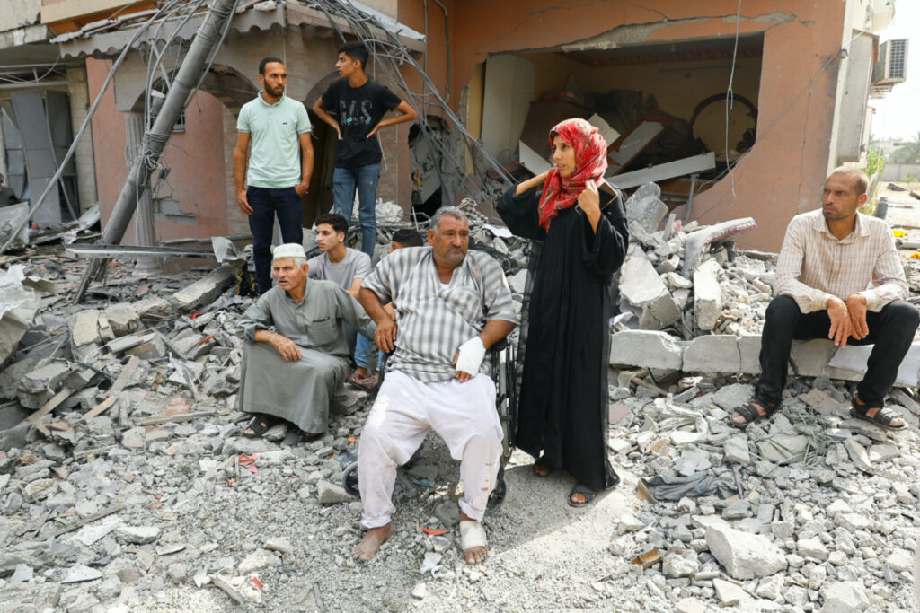 Palestinians watch the civil defense team as they search for victims trapped under the rubble of a house destroyed during Israeli strikes, in Khan Younis, in the southern Gaza Strip, on 8th October, 2023