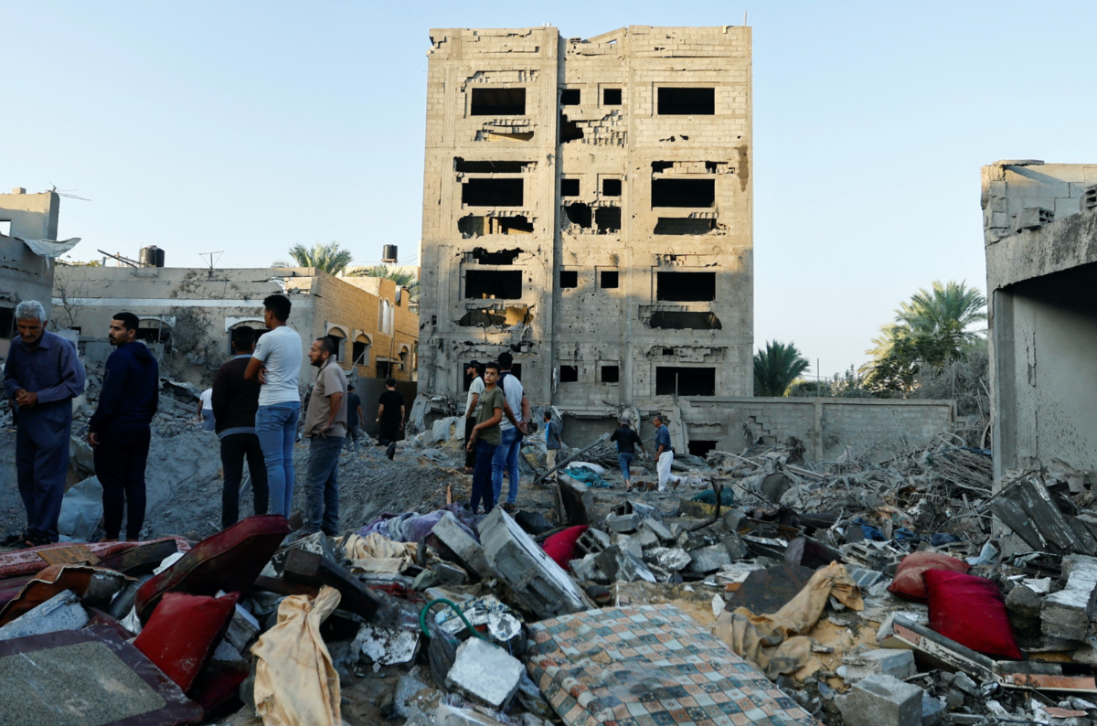 Palestinians look at the destruction of a house in the aftermath of a strike amid the conflict with Israel in Khan Younis, in the southern Gaza Strip, on 12th October, 2023