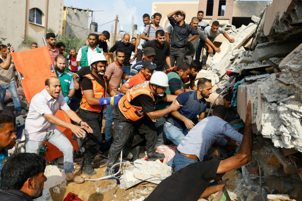 Palestinians search for casualties under the rubble of a house destroyed in Israeli strikes in Khan Younis, in the southern Gaza Strip, on 8th October, 2023