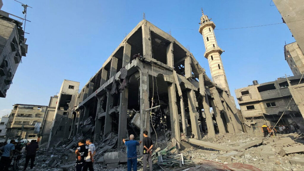 Palestinians gather around the remains of a mosque destroyed in Israeli strikes, as the conflict between Israel and Palestinian Islamist group Hamas continues, in the northern Gaza Strip, on 22nd October, 2023