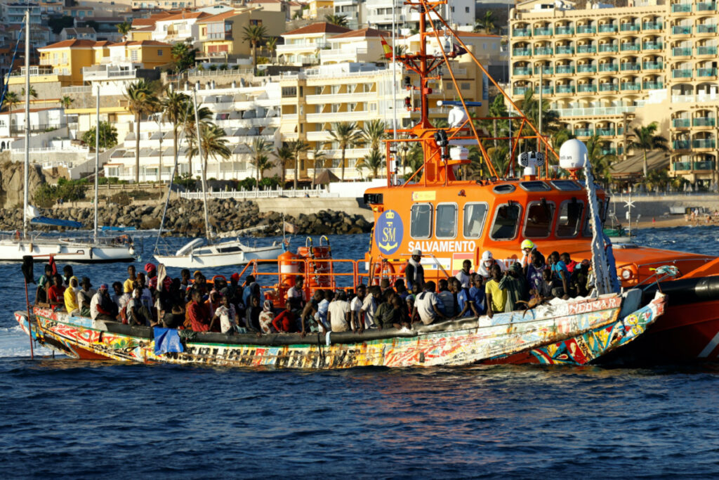 A group of migrants in a wooden boat are towed by a Spanish coast guard vessel to the port of Arguineguin, in the island of Gran Canaria, Spain, on 21st October, 2023
