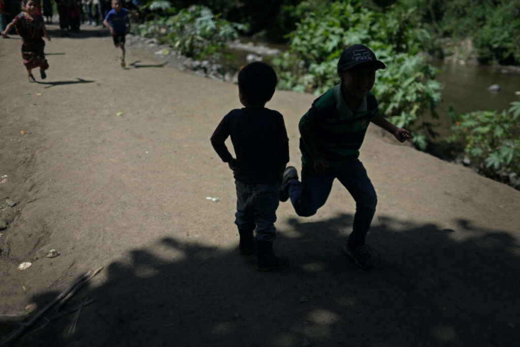 Children play next to the river in El Aguacate, Baja Verapaz, Guatemala, on 16th August, 2023.
