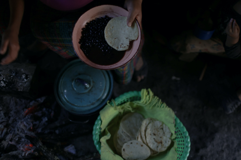 Maria Concepcion Rodriguez, 30, the mother of six children, holds a bowl of beans and a tortilla during lunch at her house in El Aguacate village in Baja Verapaz, Guatemala, on 16th August, 2023