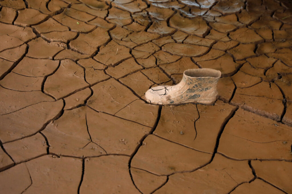 A plastic boot is pictured on dry cracked mud at a house affected by the floods due to the rains brought by Hurricanes Eta and Iota, in Villanueva, Honduras, on 6th December, 2020