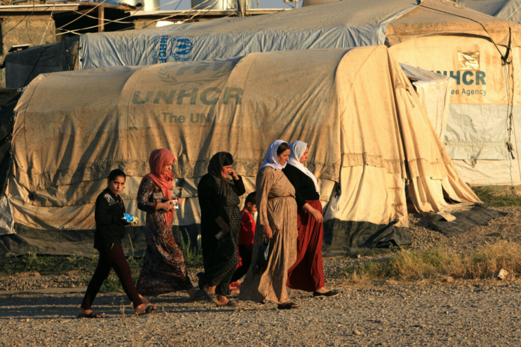 Displaced Iraqi women from the minority Yazidi sect, who fled the Iraqi town of Sinjar, walk at the Khanki camp on the outskirts of Dohuk province, on 31st July, 2019.