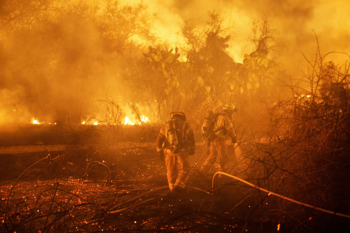 Firefighters work to put out a fire in an open field, following a mass-infiltration by Hamas gunmen from the Gaza Strip, near a hospital in Ashkelon, southern Israel, on 7th October, 2023