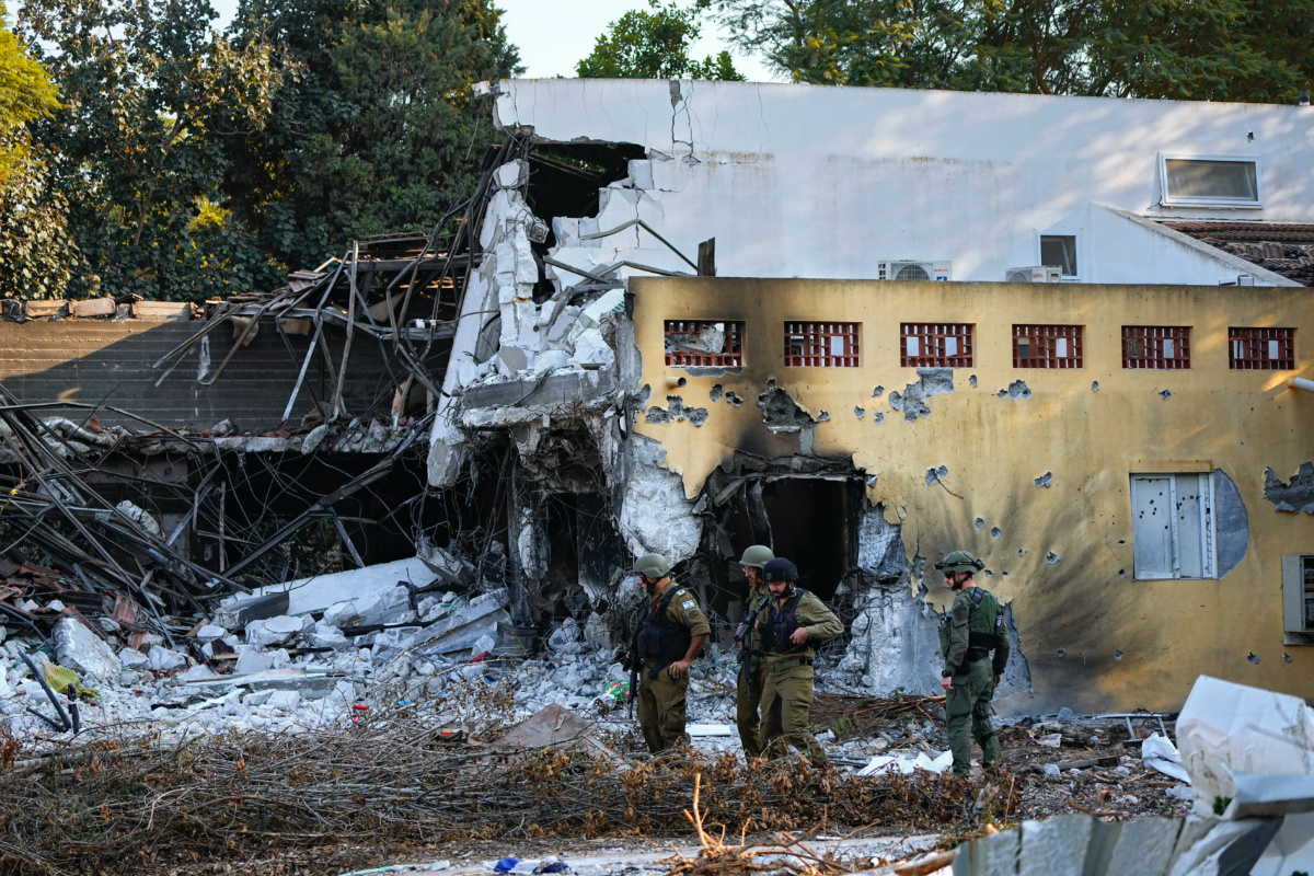 Israeli soldiers walk past houses destroyed by Hamas militants in Kibbutz Be'eri, Israel, on Saturday, 14th October, 2023