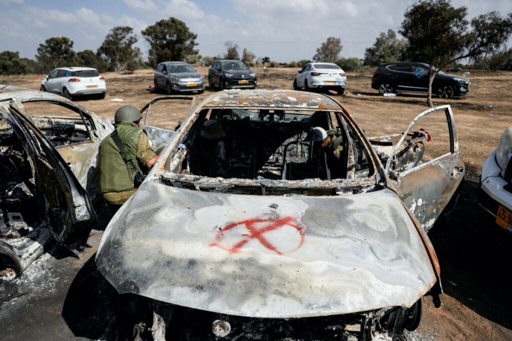 Israeli soldiers inspect the burnt car of a festival-goer at the site of an attack on the Nova Festival by Hamas gunmen from Gaza, near Israel's border with the Gaza Strip, in southern Israel, on 13th October, 2023