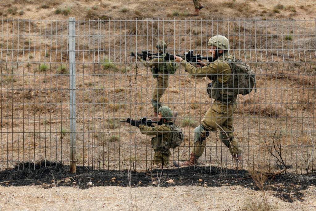 Israeli soldiers scan an area while sirens sound as rockets from Gaza are launched towards Israel,, near Sderot, southern Israel, on 9th October, 2023