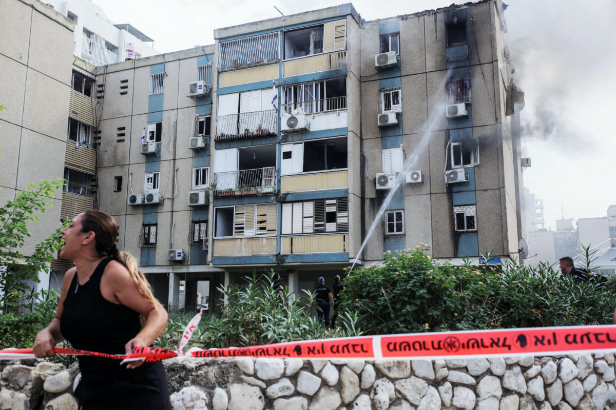 A woman calls out as smoke rises from a residential apartment building where a rocket hit, that was fired from the Gaza Strip towards Israel, in Tel Aviv, Israel, on 27th October 2023
