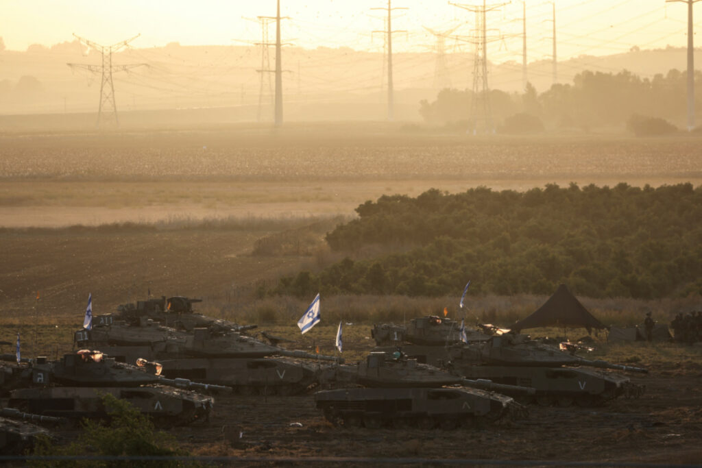 A formation of Israeli tanks and military personnel are positioned near Israel's border with the Gaza Strip, in southern Israel on 19th October